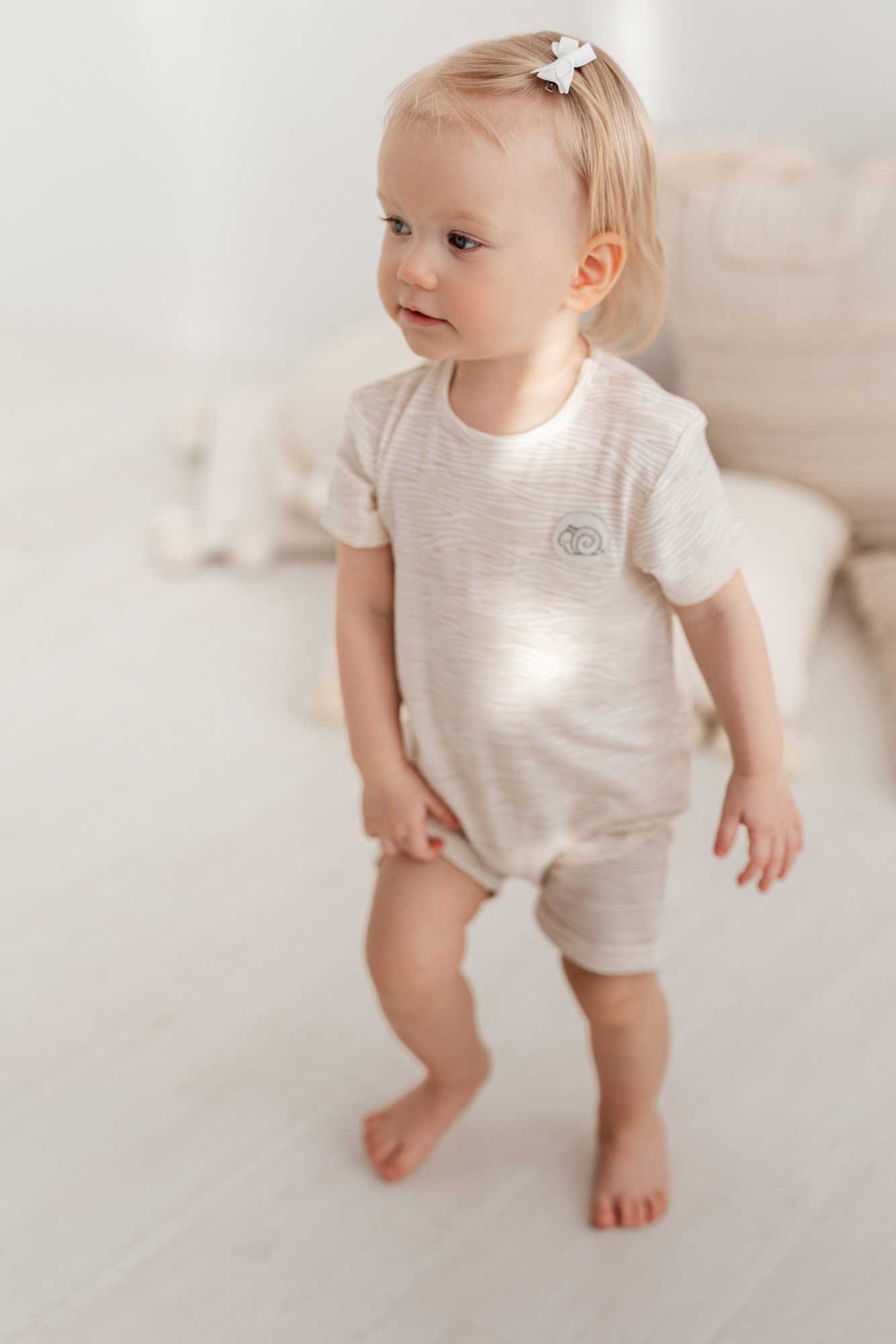 A happy child enjoying his overall with snail print