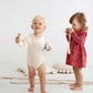 Cute blonde kid wearing infant bodysuit Bear and Bunny 368, sitting next to a girl that weares the baby dress Squirrel 361